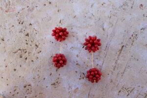 Pendientes largos de metal dorado con dos bolas de lágrimas color coral rojo de Colección Mis Buganvillas.