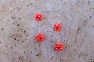 Pendientes largos de metal dorado con dos bolas de lágrimas color coral rosa de Colección Mis Buganvillas.