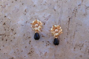 Pendientes de metal dorado con flor y lágrima color negro de Colección Mis Buganvillas.