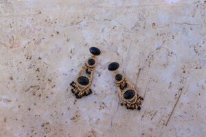 Pendientes largos de metal dorado con 3 óvalos color negro de Colección Mis Buganvillas.