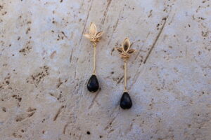 Pendientes largos de metal dorado con 3 hojas y una lágrima color negro de Colección Mis Buganvillas.