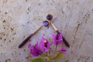 Pendientes largos de metal dorado con una estilizada lágrima color malva de Colección Mis Buganvillas.