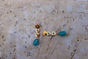 Pendientes largos de metal dorado con 3 arandelas y una lágrima color turquesa-agua marina de Colección Mis Buganvillas.