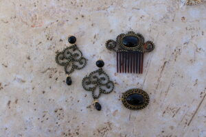 Conjunto de Pendientes largos, Peinecillo y Broche de metal dorado y metacrilato con cristalitos brillantes en color negro de Colección Mis Buganvillas.